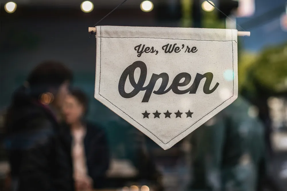 Butiksskylt med texten 'Yes, We're Open'